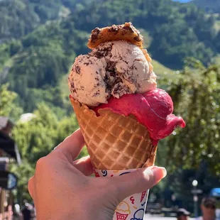a hand holding a cone of ice cream