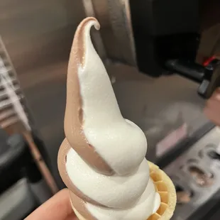 a hand holding a cone of ice cream