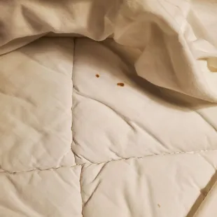 a bed with white sheets and a bed spread