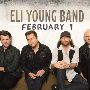 a group of men sitting on a wall