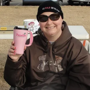 a woman holding a pink coffee mug
