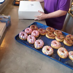 a woman holding a box of doughnuts