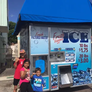 a woman and a child standing in front of a machine