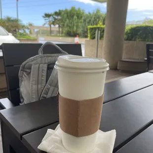 Sitting at an outdoor table enjoying my coffee