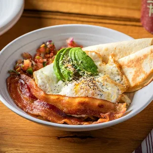 a bowl of breakfast food on a table