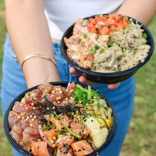 a woman holding two bowls of food