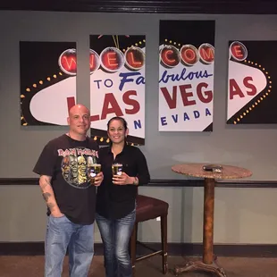 a man and a woman standing in front of a sign