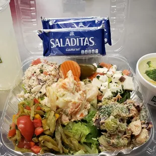 a container of salad and a drink
