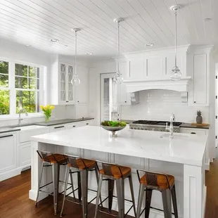 a white kitchen with a center island
