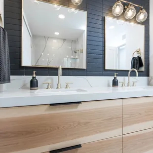 a bathroom vanity with two sinks and a large mirror