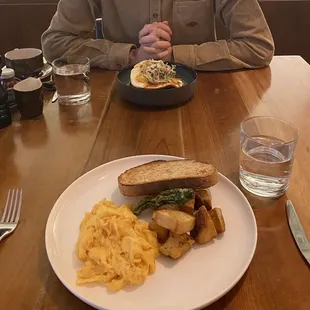 Scrambled eggs with toast and house potatoes (front), Huevos rancheros (back)