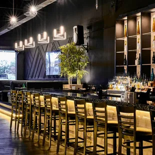 a bar with chairs and a television