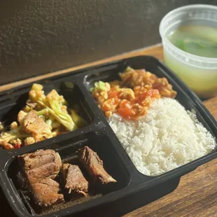 Chinese style box lunch (盒饭）with pork and cauliflower, egg and tomato stir fry, pork ribs, bok choy and egg soup and white rice