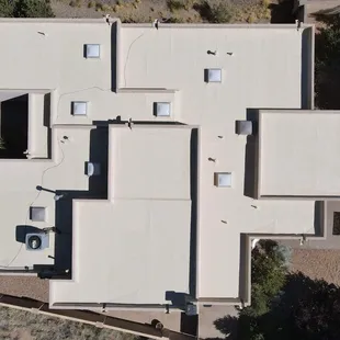 Freshly coated residential silicone roof gleaming under the midday Albuquerque sun.
