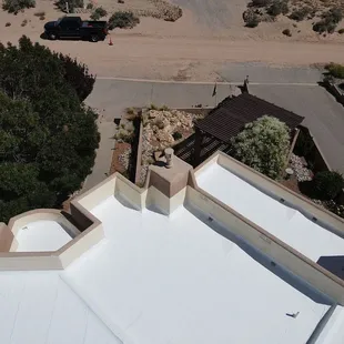 Paramount professionals ensuring a neat silicone roof coating on a terraced residential building.