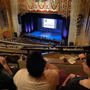 Balcony middle. They got in trouble for putting drinks on the railing. No phones during the show but before and after are OK.