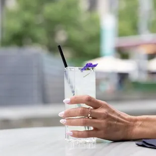 a woman's hand holding a glass of water