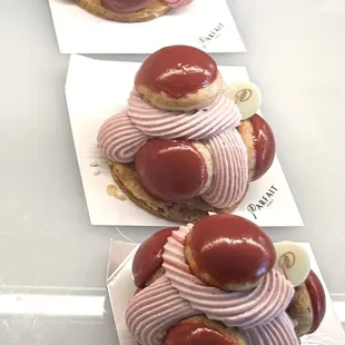 a row of pastries with pink frosting