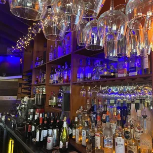 a bar with wine glasses hanging from the ceiling