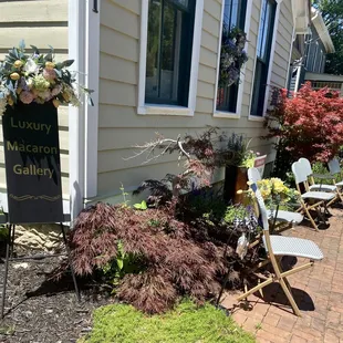the front of a house with a garden and lawn