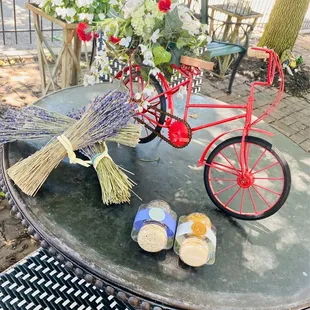 a red bicycle with a basket of flowers on a table