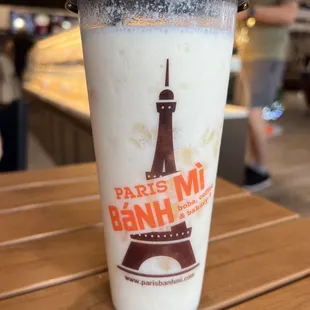a cup of milkshake with the eiffel tower in the background