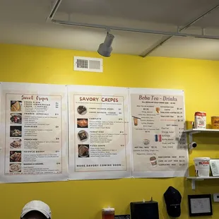 Prices are clearly displayed in a small, immaculate eating area with  cheerful yellow accent wall.