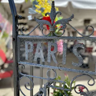 a wrought iron sign with the word paris on it