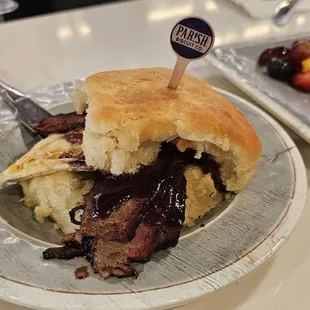 Saint Martin (Brisket Biscuit)  12 Buttermilk biscuit, smoked brisket, blueberry BBQ sauce, fried egg, pimento cheese, candied jalapenos