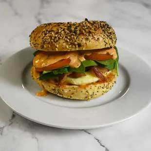 Everything bagel breakfast sandwich: Sausage, bacon, egg, pepper-jack, spinach, tomato, and mayo,
on an everything bagel