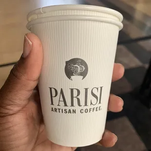 a hand holding a coffee cup