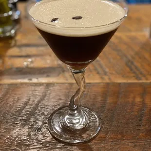 a glass of coffee on a wooden table