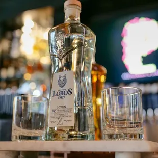 a bottle of liquor and two glasses