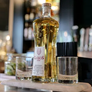 a bottle of liquor and two glasses