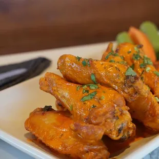 a plate of chicken wings with a side of ranch dressing