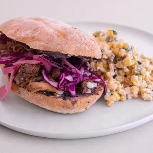 a plate with a sandwich and corn