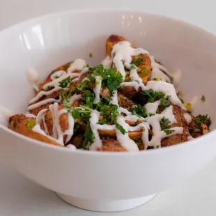 a bowl of food with sauce and parsley