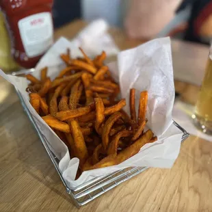 a basket of fries and a glass of beer