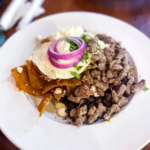 Chilaquiles w/ over easy eggs, steak and black beans (add ons)