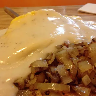 Country Benedict with crumbled eggs in place of the baisted eggs and a side of American fries with onions.