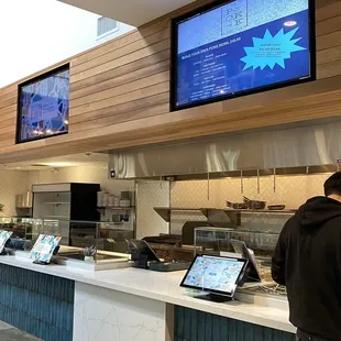 a man standing in front of a counter with laptops