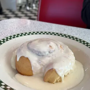 a cinnamon roll with icing on a plate