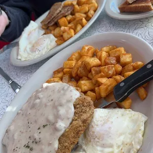 a plate of fried eggs, hash browns, and toast