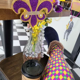 a mardi gras fleur and a cup of coffee