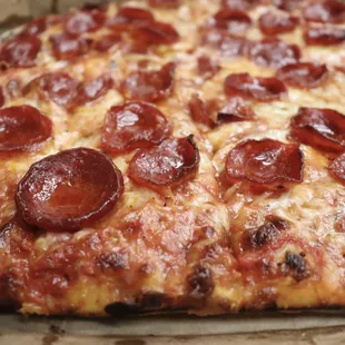 a pepperoni pizza on a pan