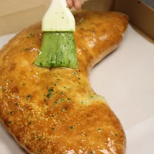 a person painting a piece of bread