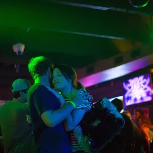 a man and a woman hugging in a bar