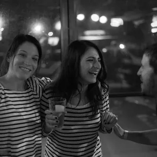 a black and white photo of two women and a man