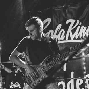 a black and white photo of a man playing a bass