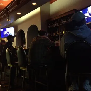 people sitting at the bar watching tv